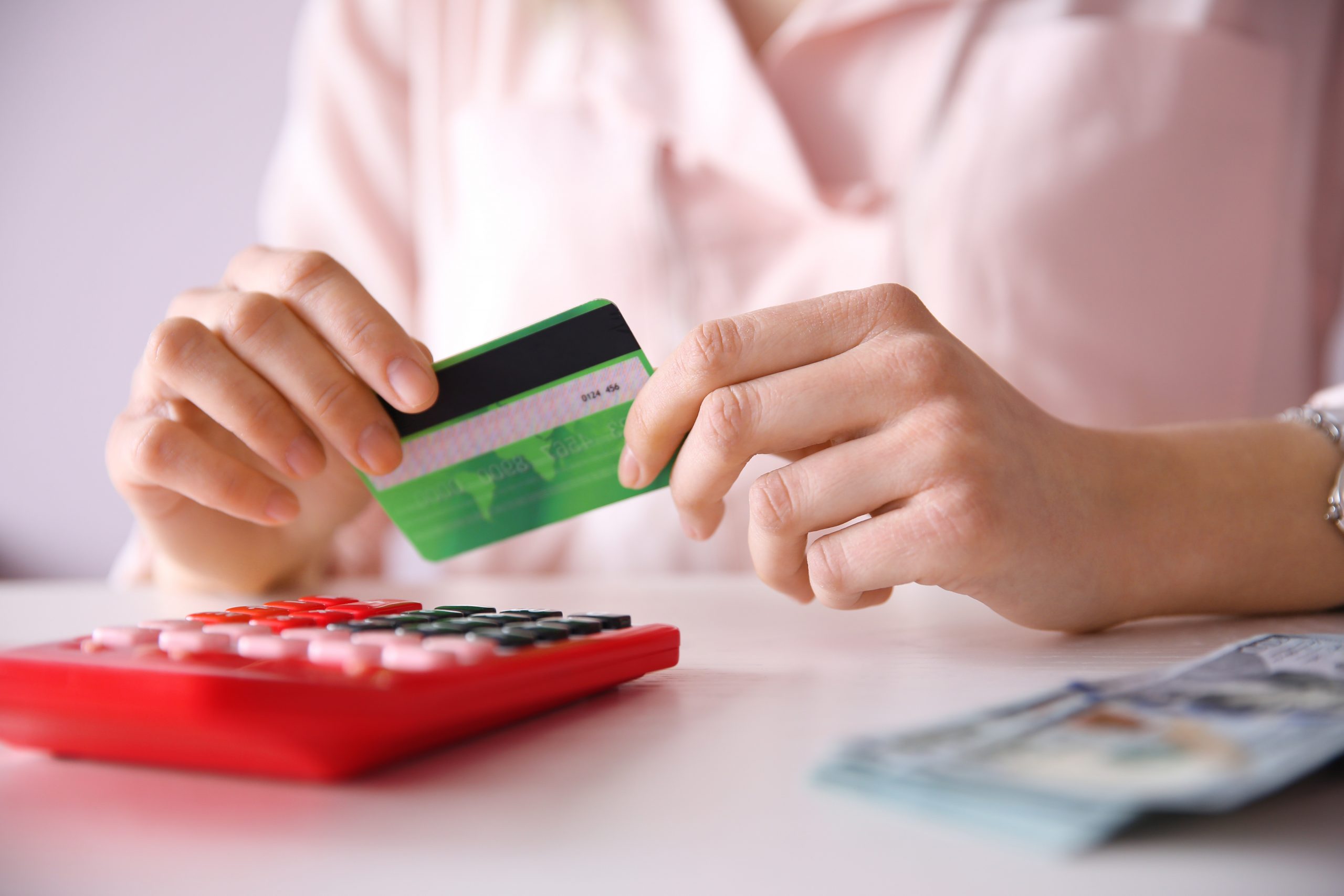 Female calculate with credit card and money, closeup