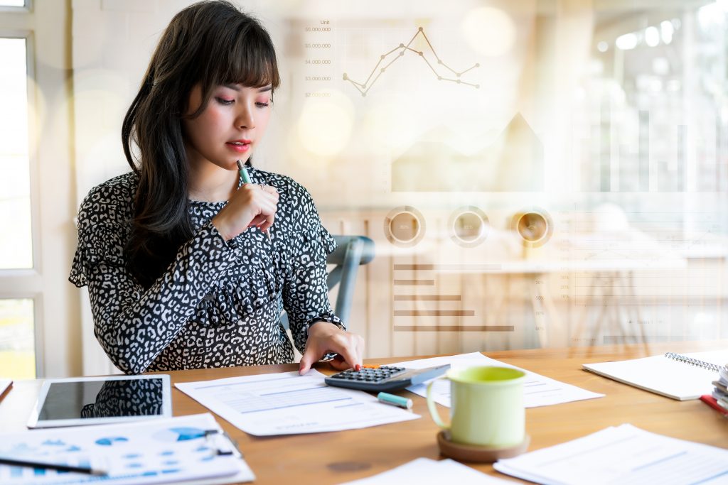 Woman working on business report using calculator