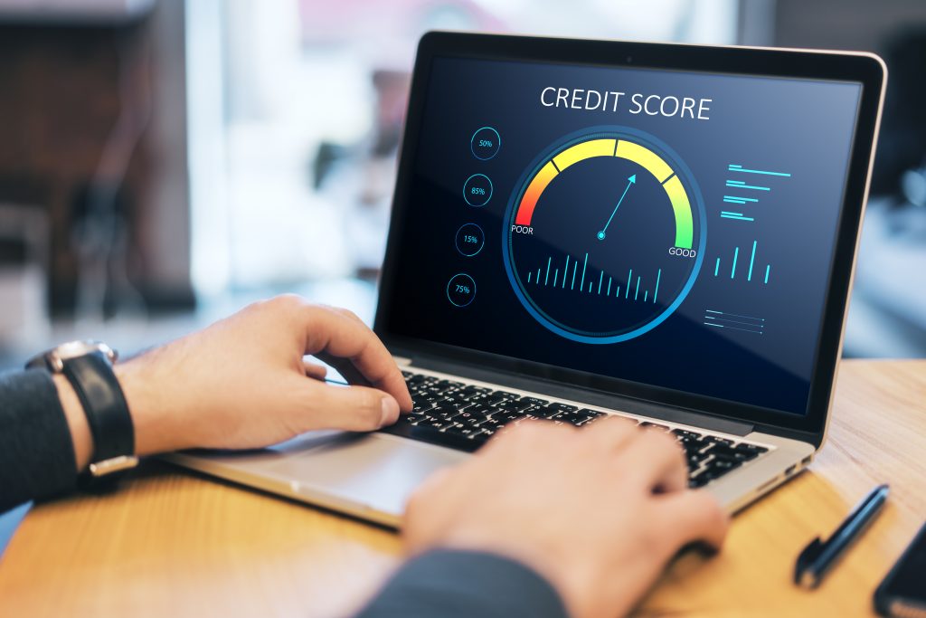 Close up of hands at wooden desktop with laptop computer and abstract credit score scale on screen