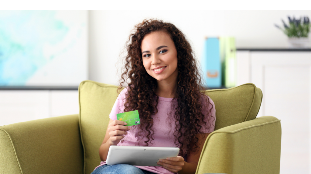 Smiling woman holding credit card and tablet