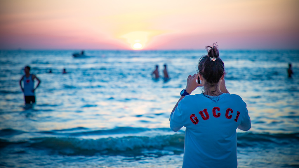 Woman dressed in gucci clothes with a binoculars looking at the horizon