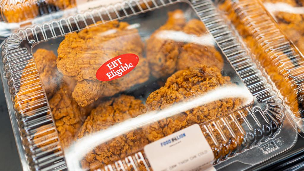 Sterling, USA - March 20, 2021: Deep fried chicken on retail display closeup in container at Food Lion grocery store supermarket with EBT eligible for Snap welfare government assistance program