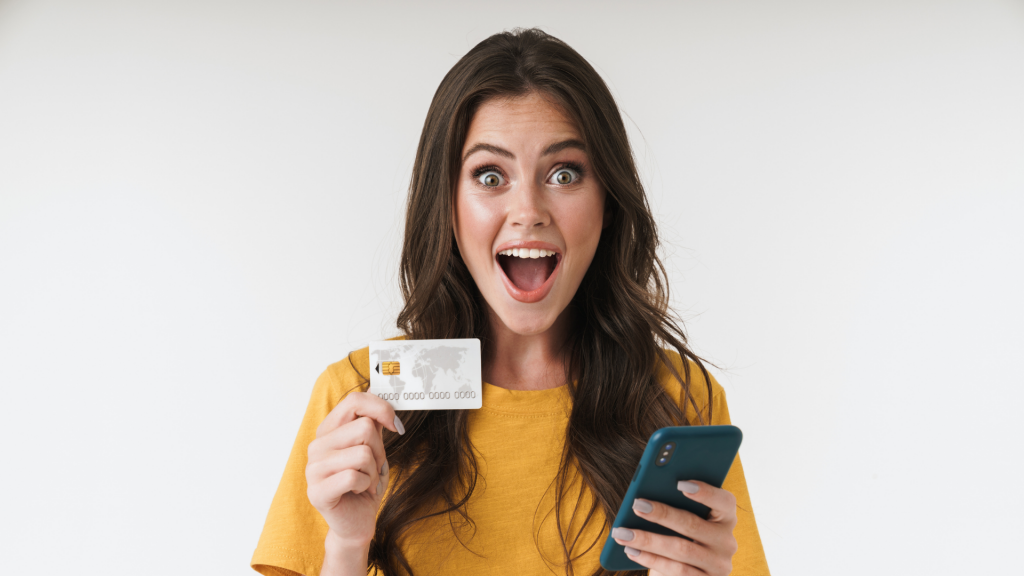 Image of gorgeous brunette woman wearing casual clothes holding credit card and cellphone