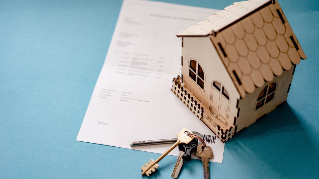 miniature house, tenure document and keys (managing your mortgage).