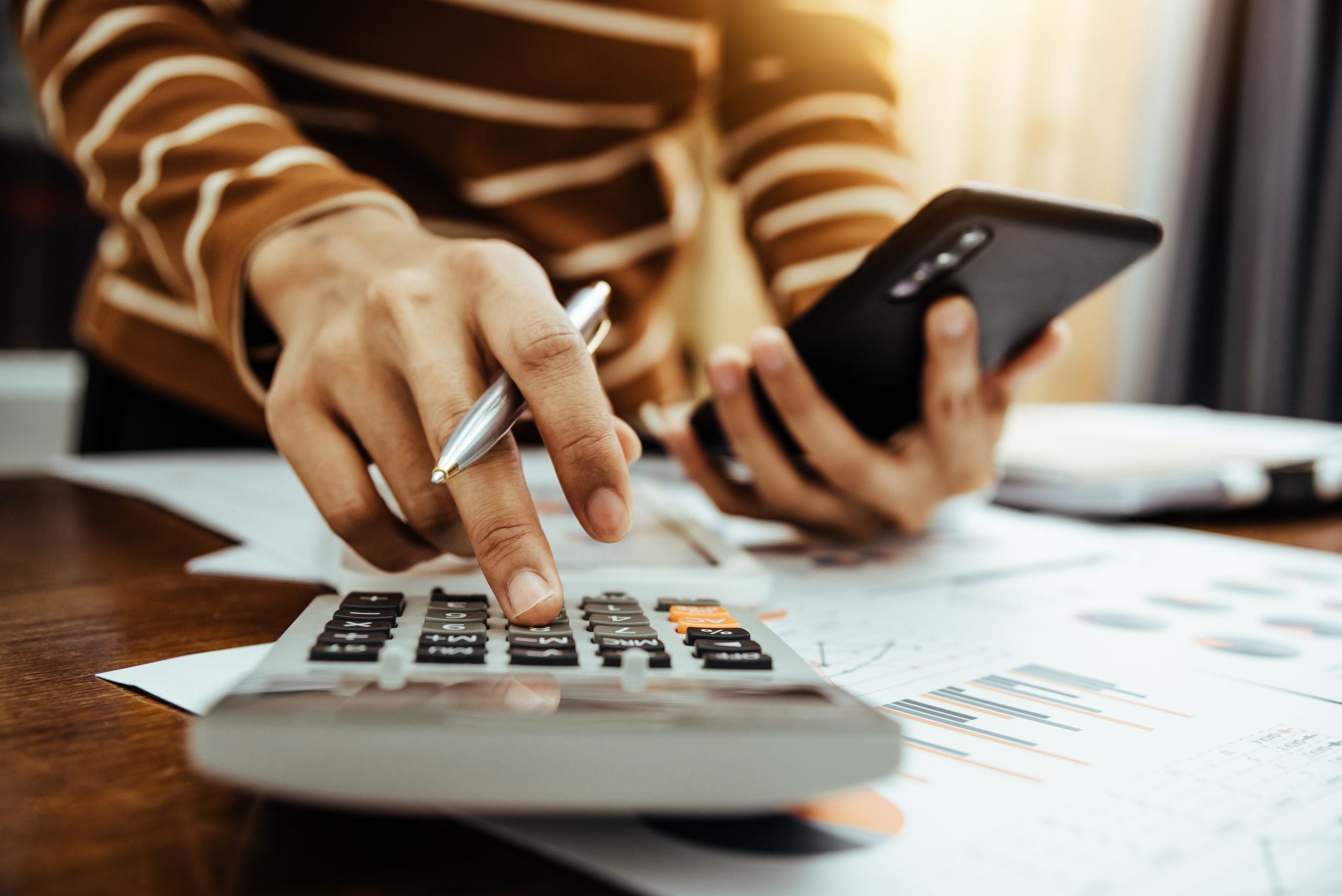 Person using calculator and cellphone