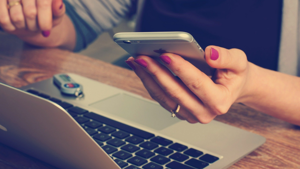 Person using notebook/laptop and smartphone