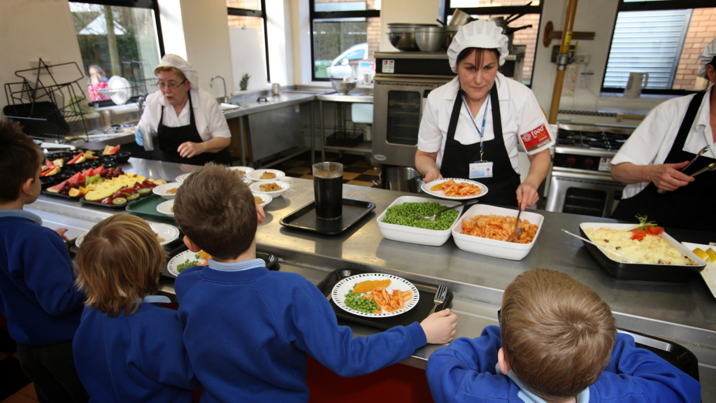 cook serving students at a school meal