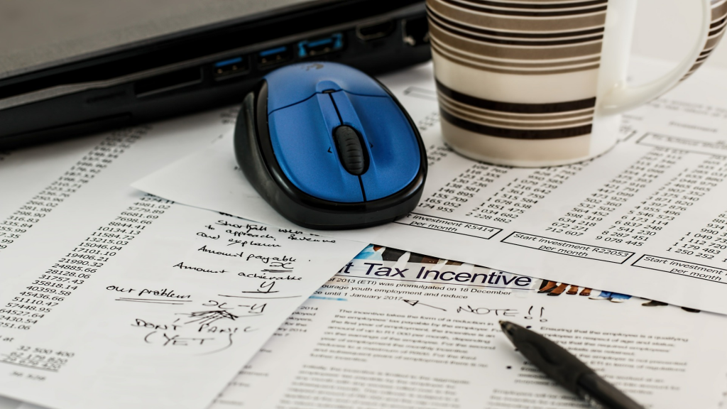 Study papers, mouse and pen scattered on a table.