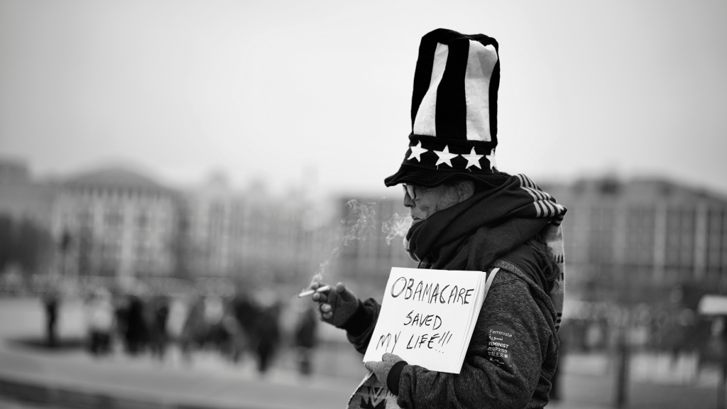 Man holding sign that says "obamacare saved my life"