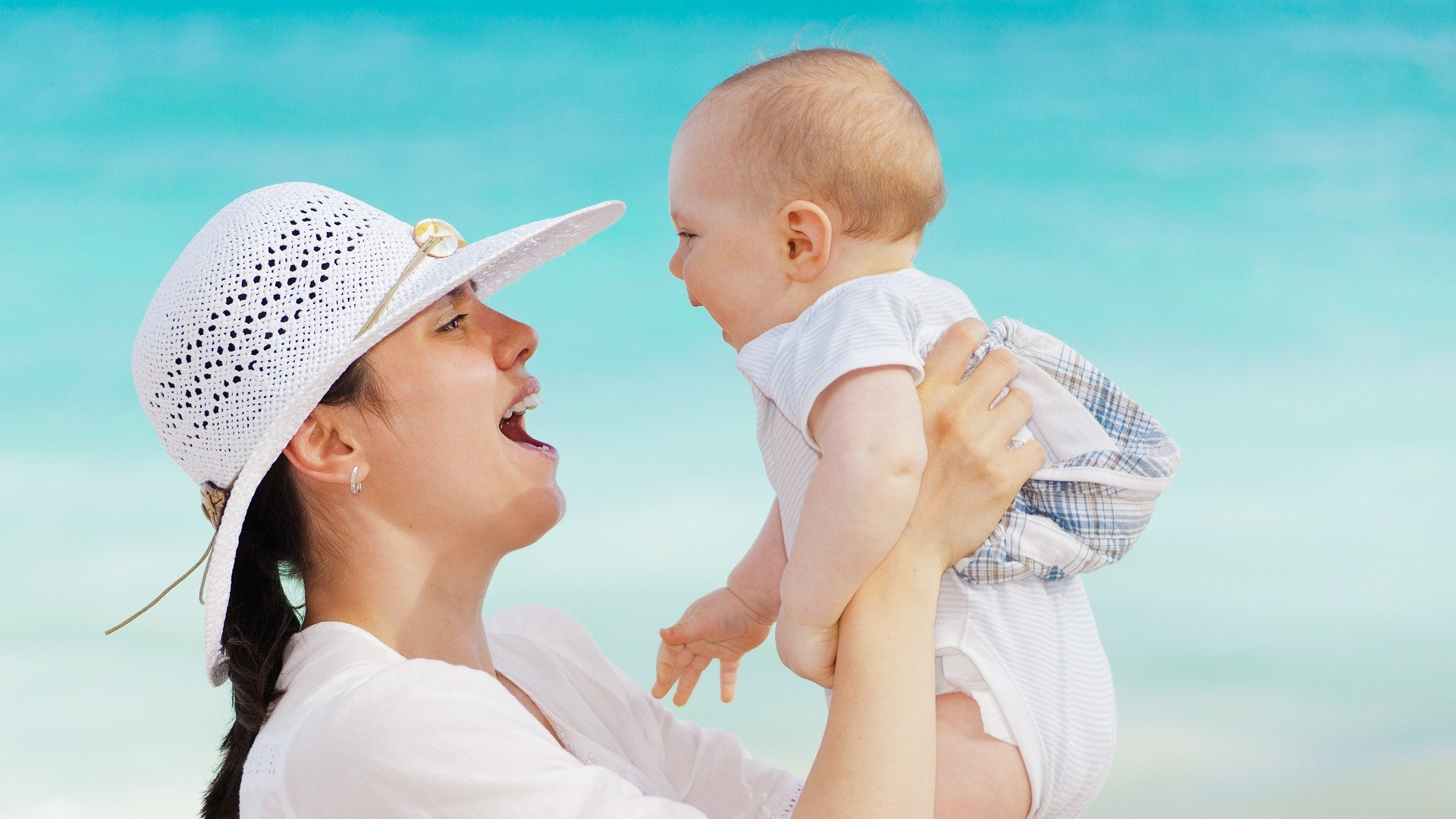 woman smiling while holding a baby