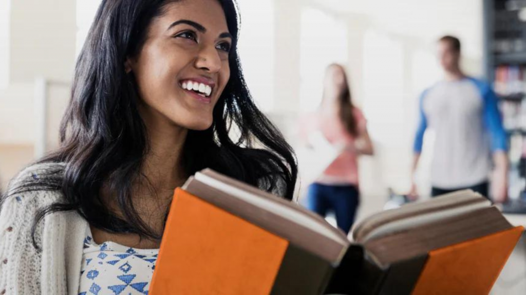 university student smiling with books