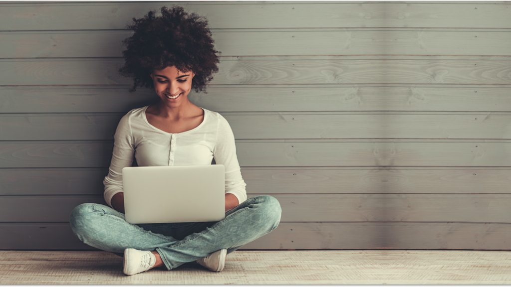 Black woman using notebook/laptop (Apply FNB Aspire Credit Card)