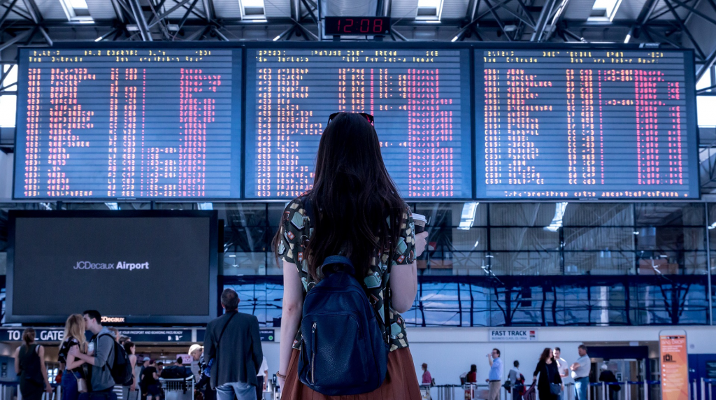 Tourist looking at a panel of airlines (international travel budget)