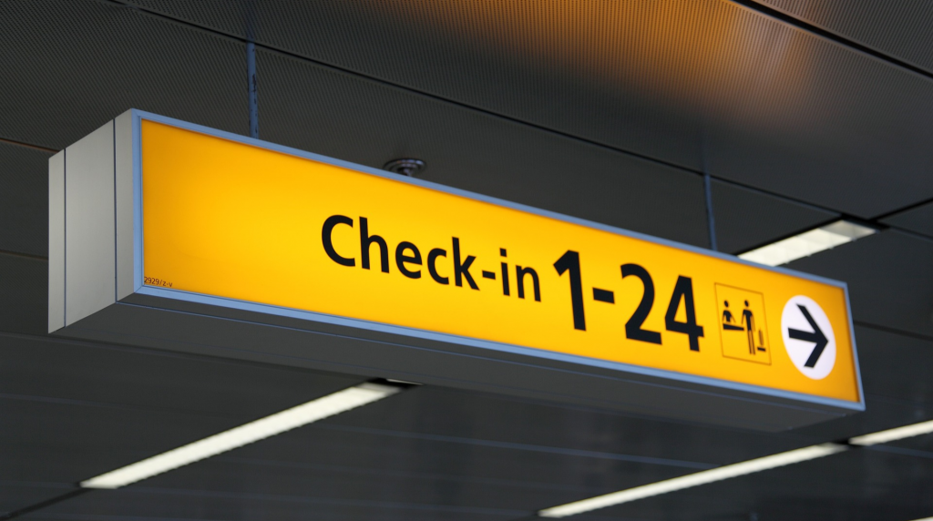 sign indicating check-in area (best flight deal)