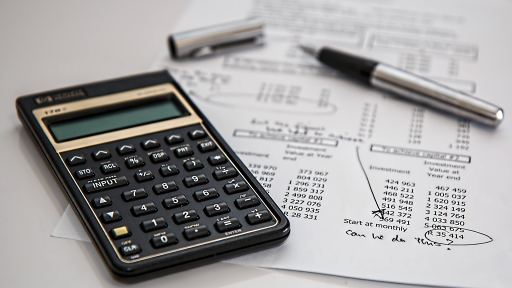 Calculating budget: calculator, pen and sheet