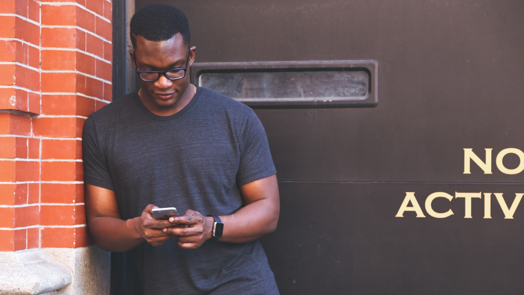 Apply Woolworths Black credit card Gold (black man using cell phone)