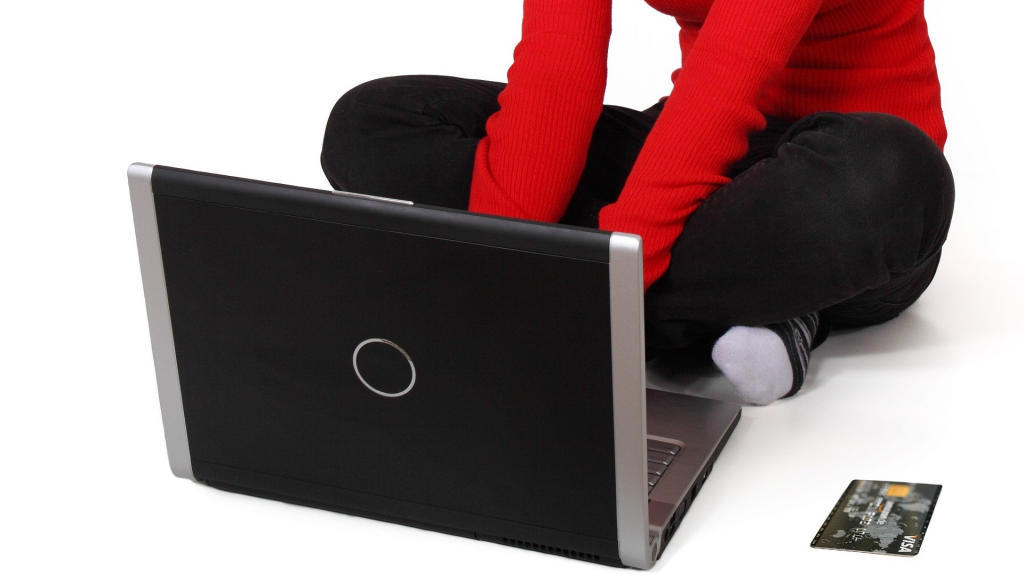 Woman using notebook with black credit card