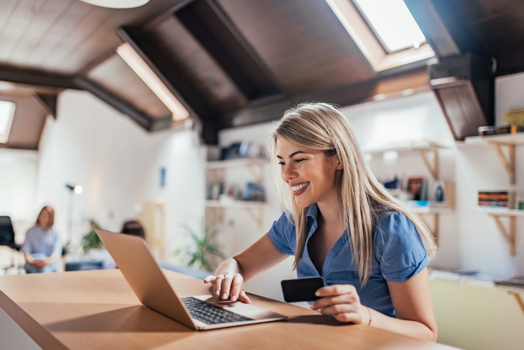 Happy young woman doing e-shopping.