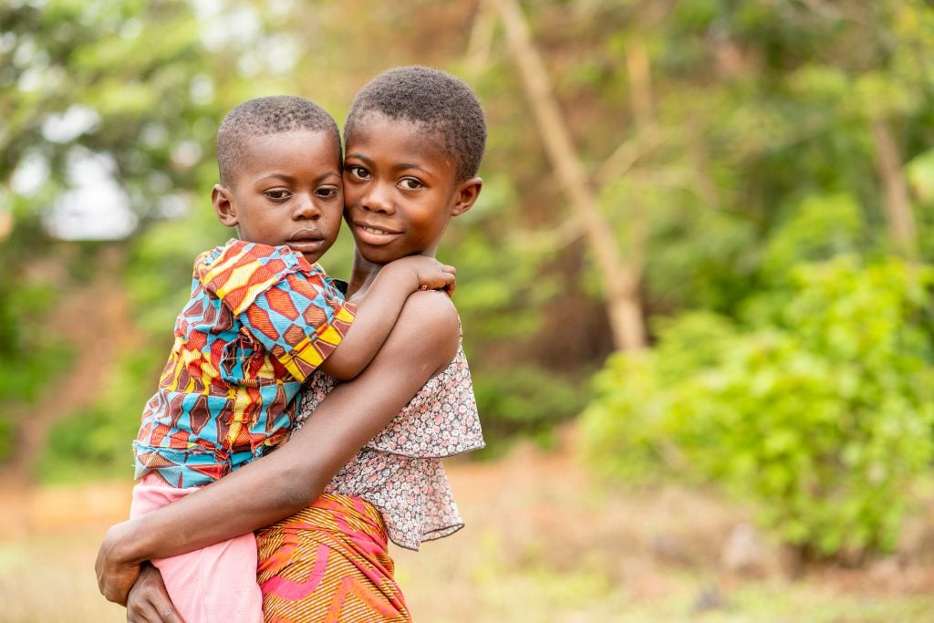 image of beautiful african siblings, young black girl carrying a