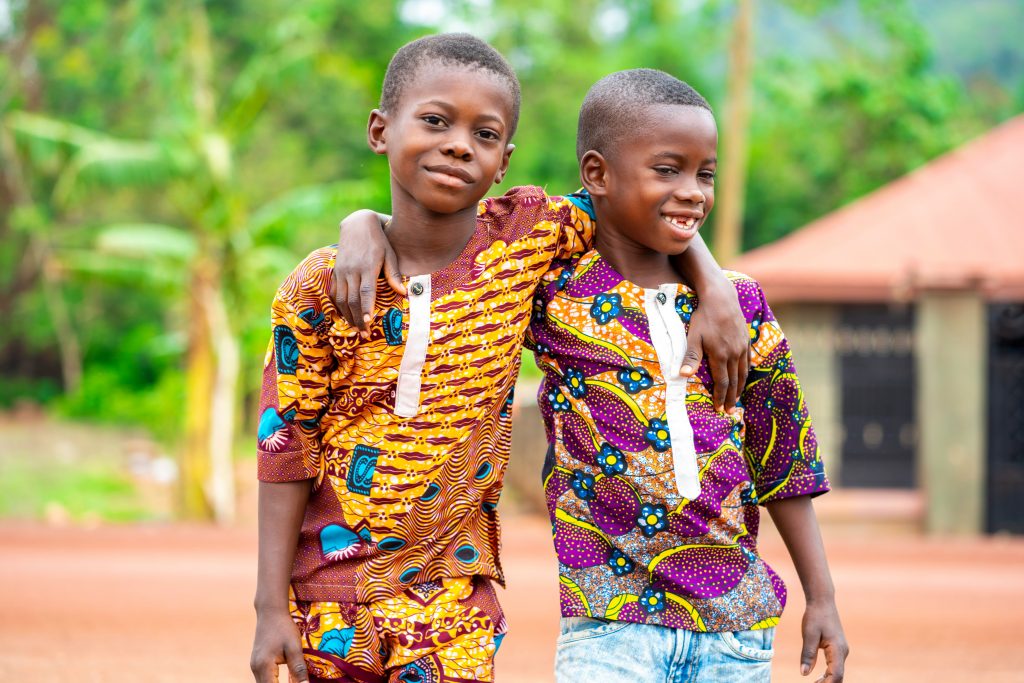 image of two young african kids holding each other- cheerful bla