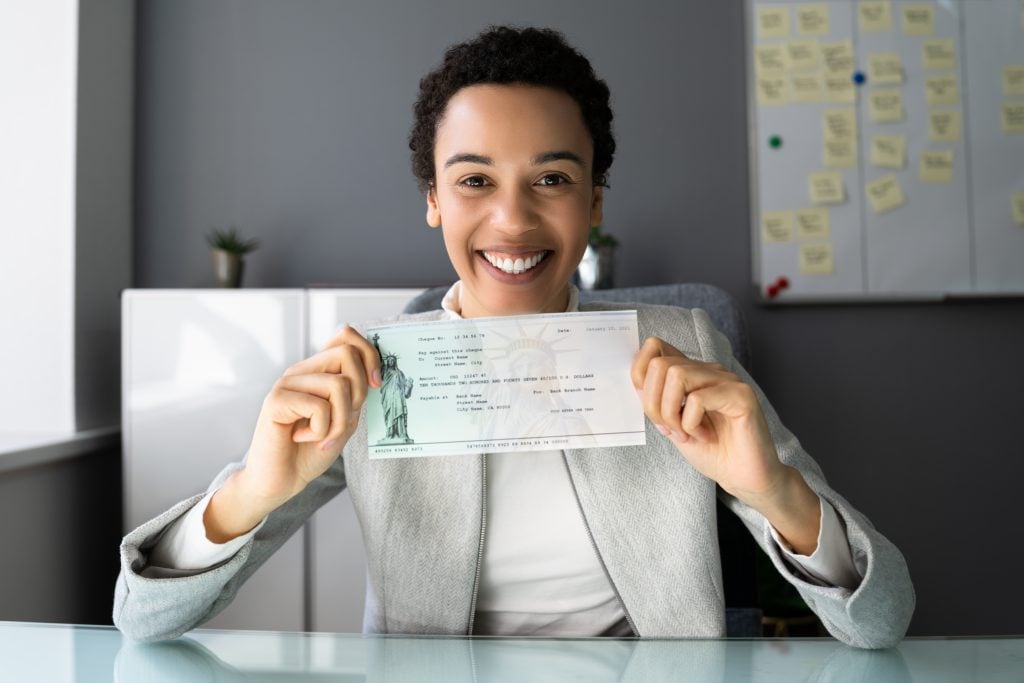 African American Women Holding Payroll Cheque