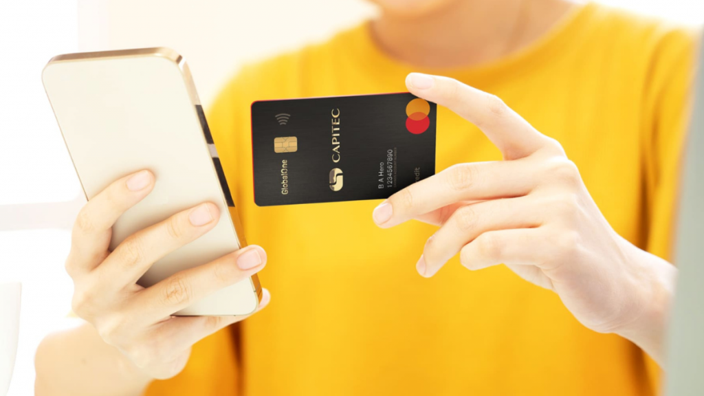 Person holding credit card and using cellphone