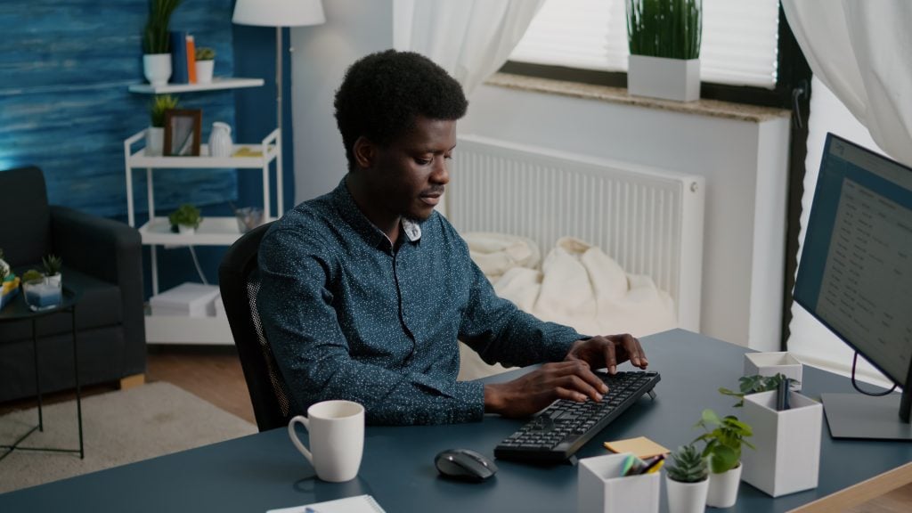 Authentic smiling black african american man working from home