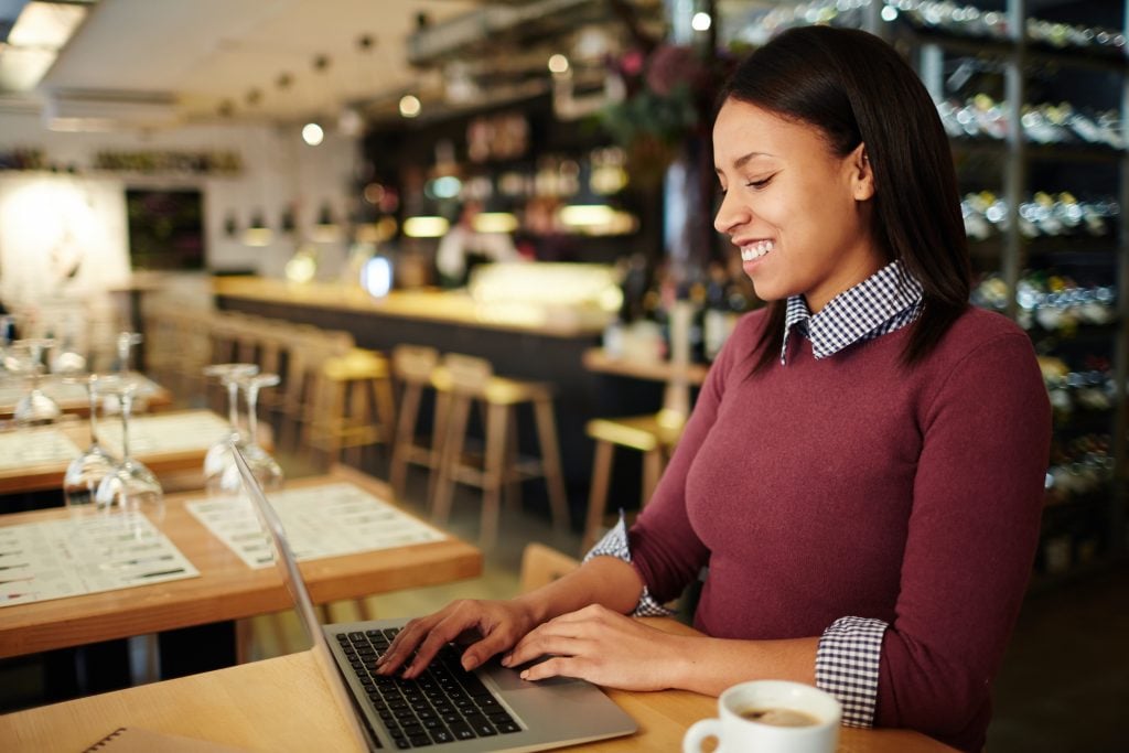 Young attractive businesswoman searching in the net during coffee break in cafe