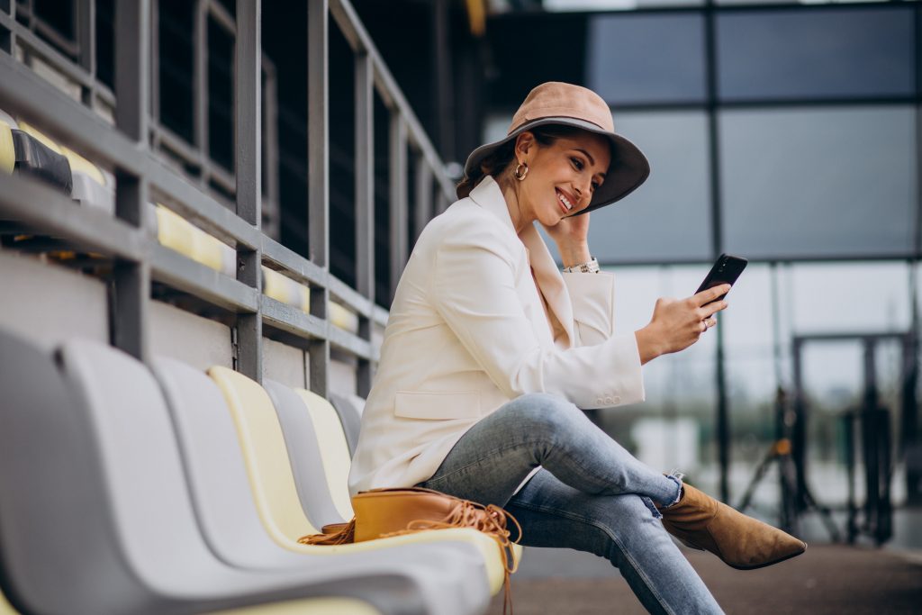 Young woman sitting on arena seats and talking on the phone