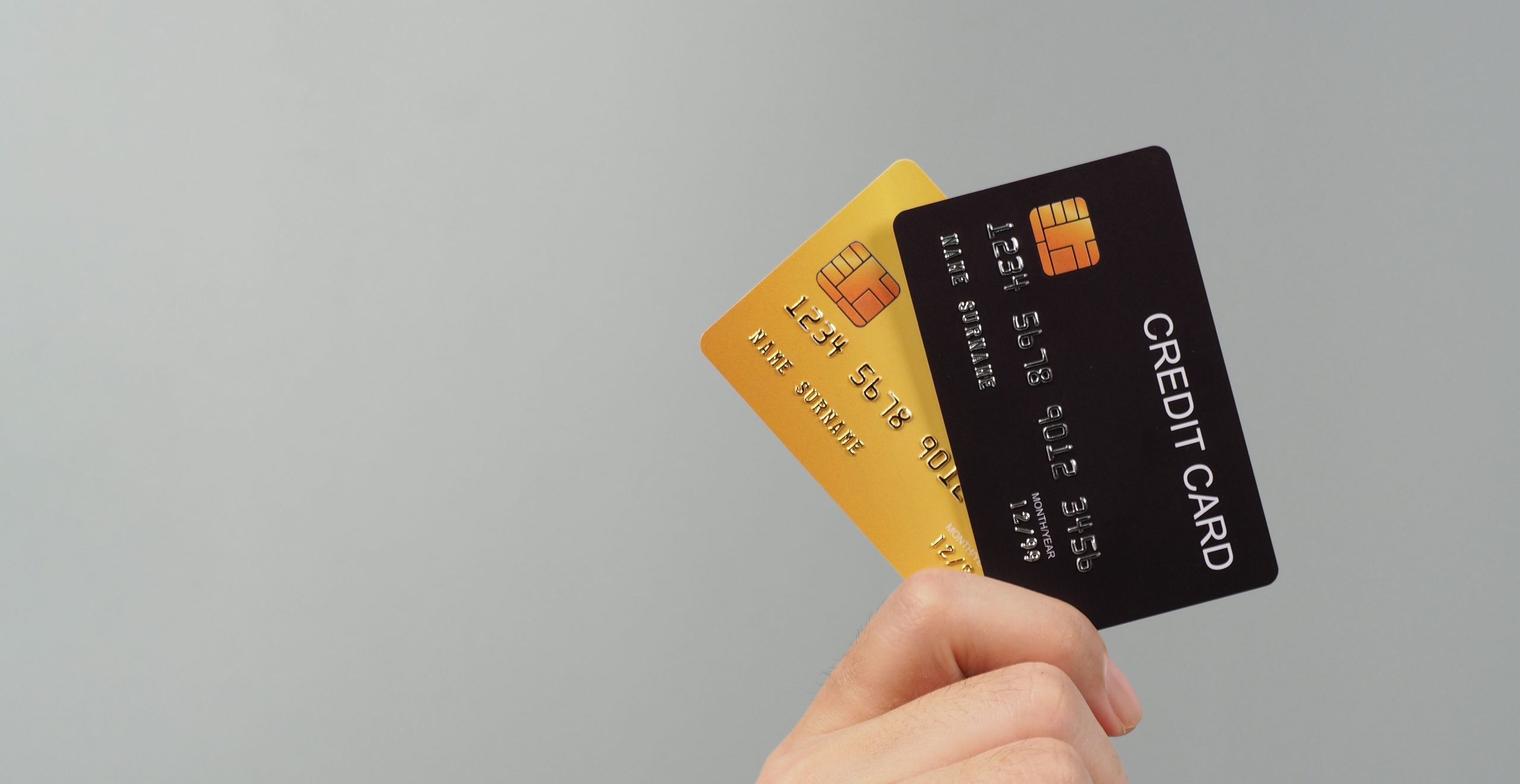 Hand is holding two credit card in black and gold color isolated