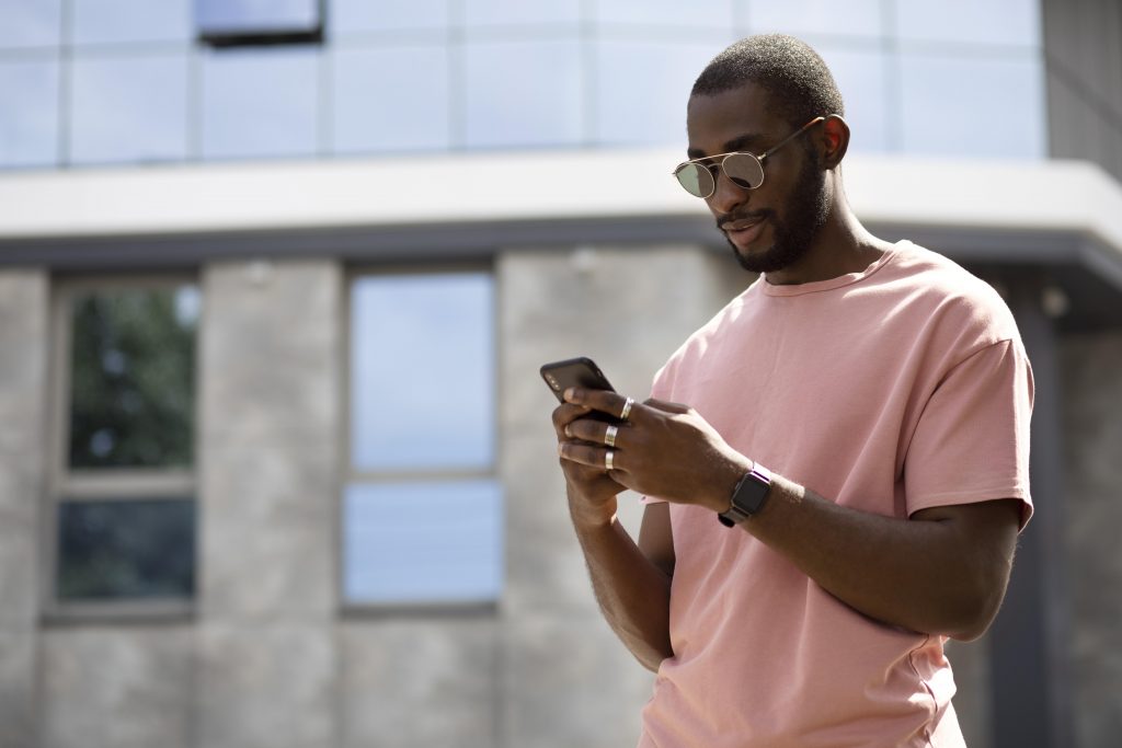 handsome-man-using-modern-smartphone-outdoors