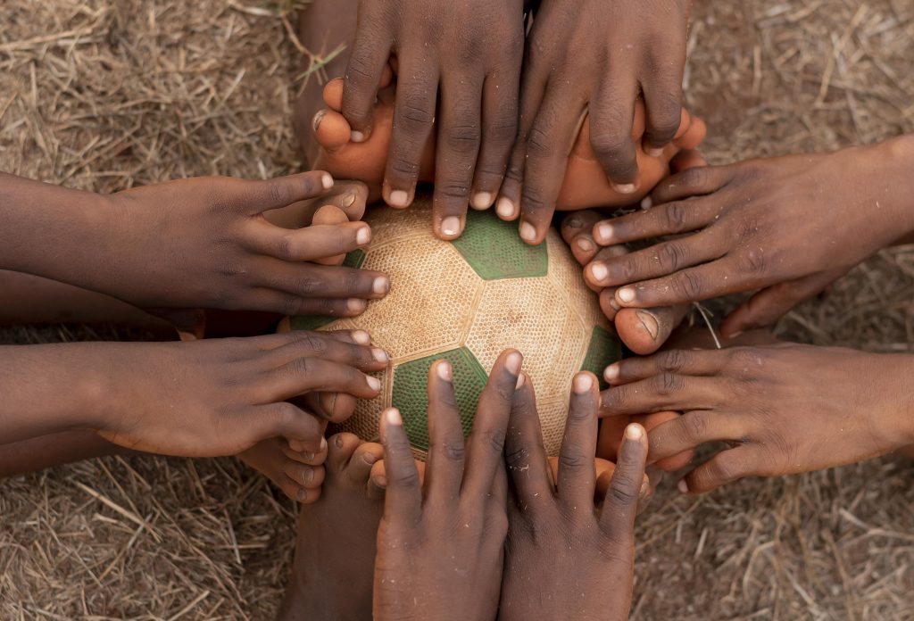 top-view-childs-feet-around-football-ball