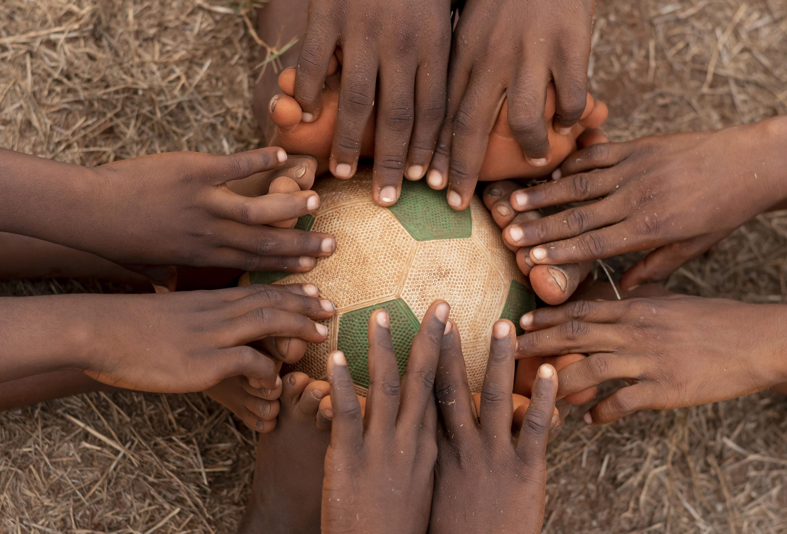 top-view-childs-feet-around-football-ball