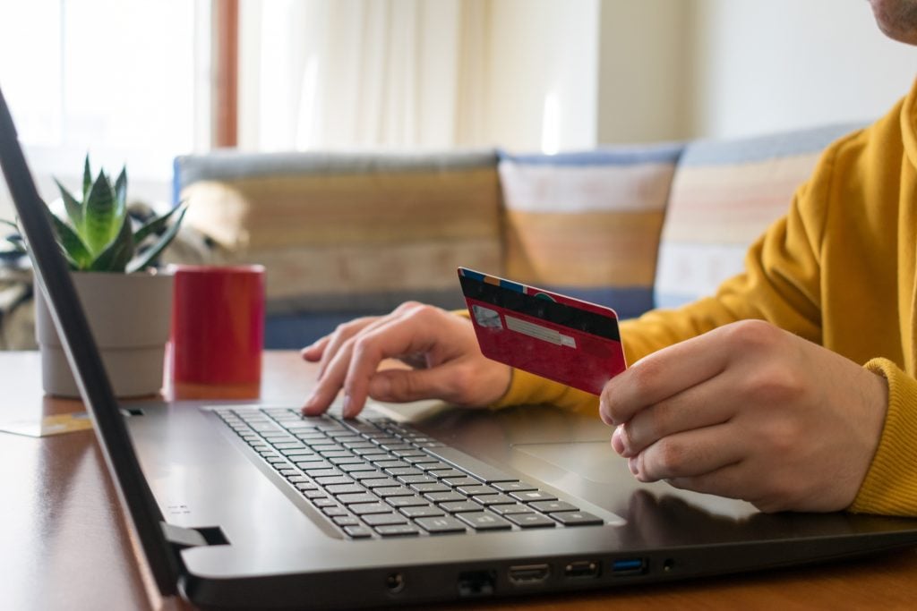 Unrecognizable person online shopping, on their laptop with a re