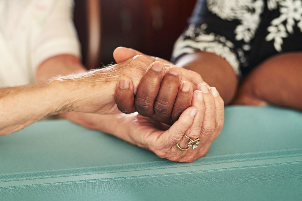 Cropped shot of a senior woman holding her friends hands in comfort.