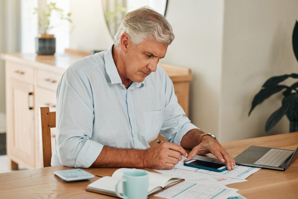 Senior, laptop and paperwork with calculator on desk use web for planning