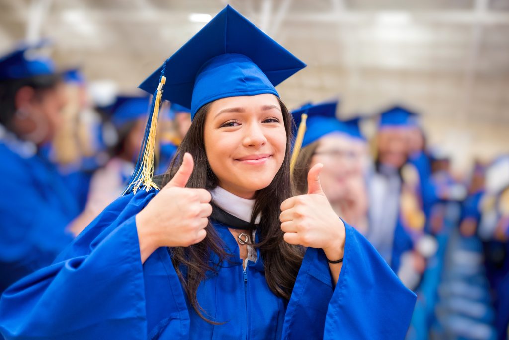 Thumbs up graduate at graduation ceremony