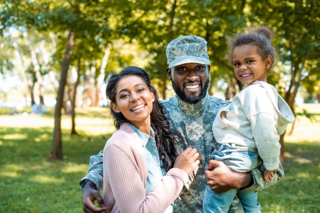 happy african american soldier in military uniform looking at ca