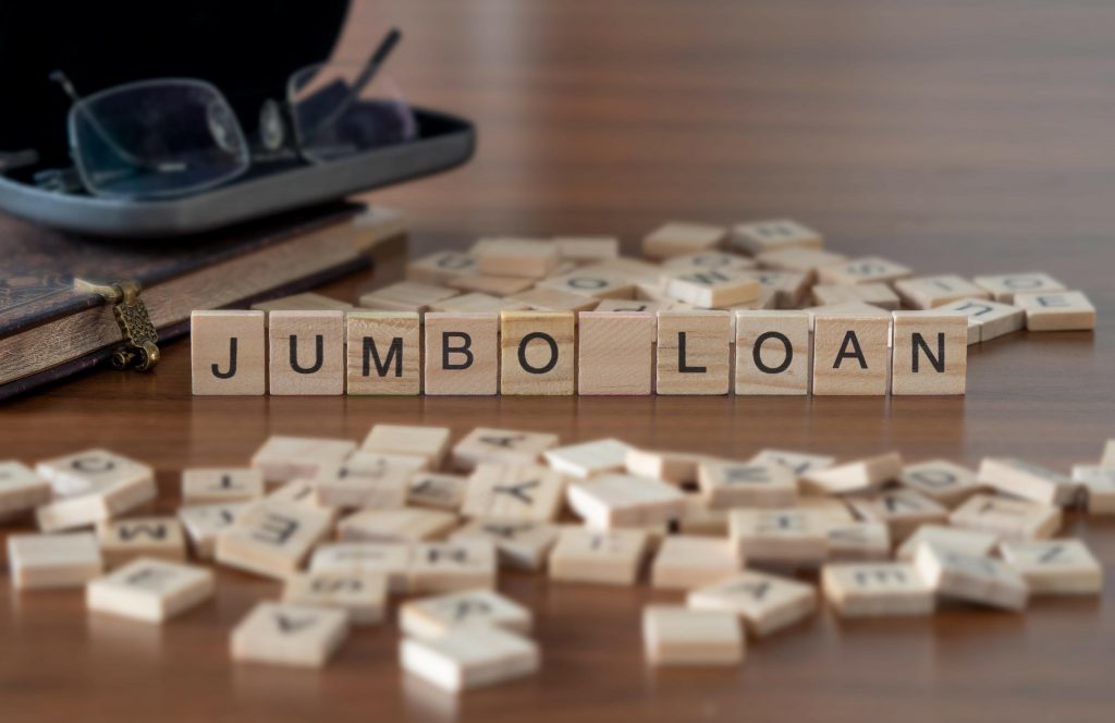 jumbo loan word or concept represented by wooden letter tiles on a wooden table with glasses and a book
