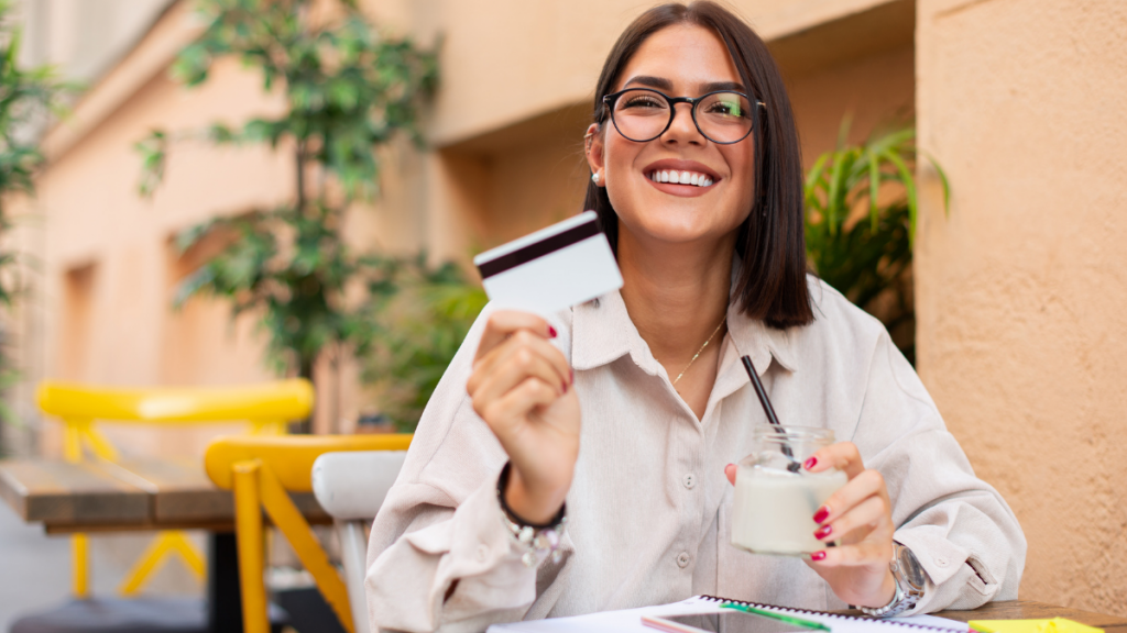 woman smiling while holding a credit card